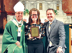 Ashley Barnett of St. Charles Borromeo Parish in Bloomington receives the archdiocese&rsquo;s 2017&nbsp;Youth Ministry Servant of the Year Award during a Mass on Sept. 5 at SS. Peter and Paul Cathedral in Indianapolis. She poses for a photo with Archbishop Charles C. Thompson and Scott Williams, the archdiocese&rsquo;s director of youth ministry. (Photos by John Shaughnessy)