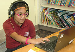 Second-grade student Makenzie Yates enjoys using an adaptive computer program at Holy Angels School in Indianapolis, a program that identifies the academic level of each student and uses fun concepts to help them progress individually and as a group. It&rsquo;s part of the school&rsquo;s comprehensive &ldquo;blended-learning&rdquo; program that has become a model in the archdiocese. (Photo by John Shaughnessy) 