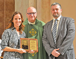 Cara and Josh Bach pose with Msgr. William F. Stumpf, archdiocesan vicar general, after receiving the Office of Pro-Life and Family Life&rsquo;s annual Archbishop Edward T. O&rsquo;Meara Pro-Life Award at SS.&nbsp;Peter and Paul Cathedral on Oct. 1. (Photo by Natalie Hoefer)