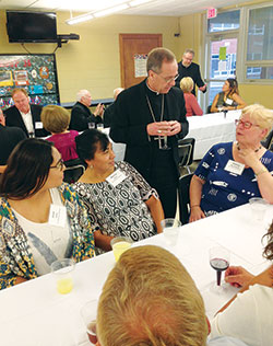 Jose Soto, left, Marisa Soto, both members of St. Ambrose Parish in Seymour, and Shirley Boardman, right, a member of St. Agnes Parish in Nashville, talk with Archbishop Charles C. Thompson during a Miter&nbsp;Society dinner on Sept. 26 at Holy Family Parish in New Albany. (Photo by Leslie Lynch)
