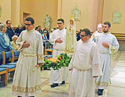 Father Patrick Beidelman, second from right, rector of SS. Peter and Paul Cathedral Parish in Indianapolis, and archdiocesan seminarians process through SS. Peter and Paul Cathedral with a statue of the Blessed Mother during a &lsquo;Morning with Mary&rsquo; on Oct. 14. Pictured with Father Beidelman are, front, from left: Liam Hosty and Matthew Perronie. Middle: Michael Clawson and Owen Duckett. (Submitted photo by Bob Kelly)