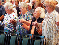 Shirley Verhonik, left, Louise David, Mary Harper and Jeanette Clements, all members of St. Joseph Parish, St. Ann&rsquo;s sister parish in Indianapolis, pray the Our Father during the Oct. 7 centennial Mass. Harper was a longtime member of St. Ann Parish and baptized in its church in 1920. (Photo by Mike Krokos)