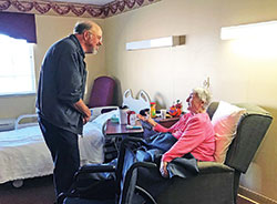 Deacon Ronald Freyer, left, listens to Franciscan Sister Francis Clements during a visit to St. Andrews Health Campus in Batesville on Oct. 22. Visiting the sick in hospitals and nursing homes in the southeastern Indiana town is part of Deacon Freyer&rsquo;s ministry. (Submitted photo by Katie Rutter)