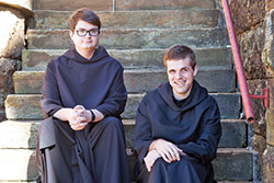 Benedictine Brothers Joel Blaize, left, and Kolbe Wolniakowski sit on the steps of the Archabbey Church of Our Lady of Einsiedeln in St. Meinrad. The two monks of Saint Meinrad Archabbey are the hosts of the &ldquo;Echoes from the Bell Tower&rdquo; podcast that features &ldquo;stories of wit and wisdom from Benedictine monks who live, work and pray in southern Indiana.&rdquo; (Photo courtesy of Saint Meinrad Archabbey)