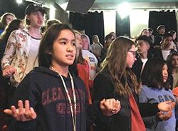 Young members of St. Luke the Evangelist Parish in Indianapolis join hands to pray the Our Father prayer during Holy Fire in Chicago&rsquo;s UIC Pavilion on Oct. 21. Pictured are Dannielle Le, left, Josie Esposito and Mira Solito. (Submitted photo by Katie Rutter)