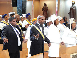 Members of St. Rita Parish&rsquo;s Knights of Peter Claver and Ladies Auxiliary hold hands while praying the Lord&rsquo;s Prayer on Oct. 22 during their organizations&rsquo; 70th anniversary Mass at St. Rita Church in Indianapolis. (Photo by Mike Krokos)