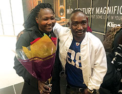 The joyous reunion of a parent and child shows as Bershlmaws &ldquo;Alo&rdquo; Koko greets his mother, Nasra Anglo, with a bouquet of red roses on Oct. 19 at Indianapolis International Airport. Alo, a refugee of Sudan who came to the United States in January, was reunited with nine members of his family on that October evening. (Submitted photo)