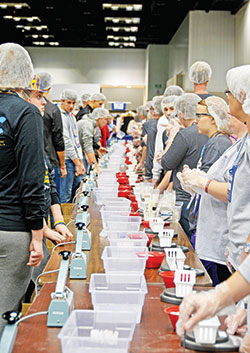 In the Indiana Convention Center in Indianapolis during the National Catholic Youth Conference, volunteers prepare to make pre-packed meals on Nov. 18 to be sent to Burkina Faso as part of a conference-long service project to help Catholic Relief Services&rsquo; Helping Hands program. (Photo by Natalie Hoefer)