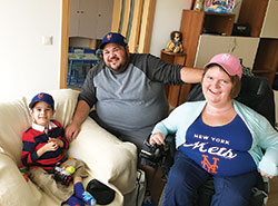 Russ and Katrina Kelly, members of St. Mary Parish in Indianapolis, pose with their adopted son, 5-year-old Gosho, at his orphanage in Bulgaria last October. The 5-year-old boy shares the same condition as his adoptive mother&mdash;spinal muscular atrophy. (Submitted photo)