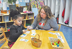 Teacher Heather Keeney helps Ja&rsquo;Niyla McFerson learn numbers on Jan. 10 in the Kids Care pre&shy;kindergarten program at St.&nbsp;Lawrence School in Indianapolis. (Photo by Sean Gallagher)