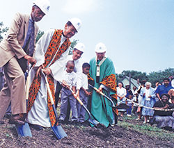 Archbishop Daniel M. Buechlein, right, breaks ground on Aug. 9, 1998, on the grounds of Holy Angels Parish in Indianapolis for a new school building for the faith community. It was the first new center-city Catholic school in the U.S. constructed in 40 years. Breaking ground with Archbishop Buechlein are Holy Angels parishioner Ted Gary, left, Father&nbsp;Clarence Waldon, pastor, Indianapolis Mayor&nbsp;Stephen Goldsmith, and Holy Angels third graders Evan Carpenter and Jonathan Butler. (File photo by Margaret Nelson)