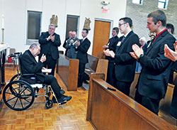Archbishop Daniel M. Buechlein gives a thumbs up to the seminarians and guests who applaud him after an April 21, 2013, prayer service at Bishop Simon Brut&eacute; College Seminary in Indianapolis. The retired archbishop was honored after the service for founding the seminary in 2004. (File photo by Sean Gallagher)