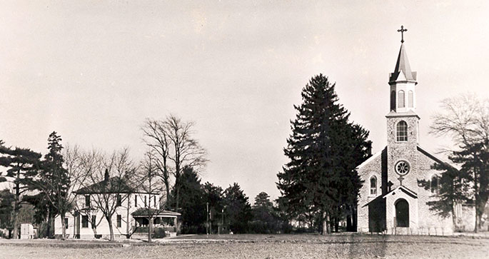 This photo shows the original church and rectory of the former St. Mary Magdalene Parish in Ripley County. The original grounds of the parish were located within what later became the Jefferson Proving Ground, a munitions testing facility operated by the U.S. Army. The land for the proving ground was selected in December 1940. St. Mary Magdalene and several other churches that were located within the proving ground were forced to close or move. The final Mass in the original church was celebrated on Feb. 16, 1941, by then-Bishop Joseph E. Ritter. The parish was closed for six years before being re-opened in 1947&nbsp;in New Marion. St. Mary Magdalene Parish was merged in December 2013 with Prince of Peace Parish in Madison as part&nbsp;of the &ldquo;Connected in the Spirit&rdquo; planning process.