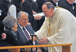 Benedictine Archabbot Kurt Stasiak, leader of Saint Meinrad Archabbey in St. Meinrad, gives a sign of peace to Marge and Charles Buechlein of Jasper, Ind., the sister-in-law and brother of Archbishop Emeritus Daniel M. Buechlein, during a Feb. 1 Mass for a Deceased Bishop in the monastery&rsquo;s Archabbey Church of Our Lady of Einseideln. The Mass was part of the funeral rites for&nbsp;Archbishop&nbsp;Buechlein. (Photo by Sean Gallagher)