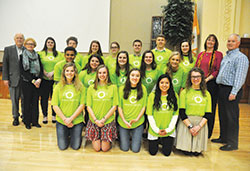 Recipients of scholarships for 2018 from the Brooke Nicole Lahr Memorial Fund for International Mission Work pose on Feb. 26 in the Archbishop Edward T. O&rsquo;Meara Catholic Center in Indianapolis. They are, from left, front row: Allison Stump, Lainey Scroggins, Lily Johnson, Marta Schmitz and Sydney Traylor. Middle row: Shawn (Chandler) Sims, Sarah Wood, Abby Harkness, Malorie Weisenbach and Sarah Scheidler. Back row: Marguerite McMahon, Michael McNulty, Morgan Sell, Katie Barnes, Parker Williams, Nicholas Sellers and Maggie Peck. Colleen and Mark Lahr, Brooke&rsquo;s parents, pose at right. Dave and Sandy Lahr, grandparents of Brooke, pose at left. (Photo by Sean Gallagher)
