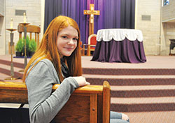 Elizabeth Werner, a freshman at Indiana University (IU) in Bloomington, sits on Feb. 15 in the church of St. Paul Catholic Center in Bloomington. Werner&rsquo;s faith has grown over her first year at IU through the increasing campus ministry efforts sponsored by St. Paul and missionaries from the Fellowship of Catholic University Students. (Photo by Sean Gallagher)