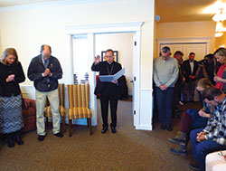 Archbishop Charles C. Thompson blesses the Women&rsquo;s Care Center in Bloomington on March 7 while supporters, staff, volunteers and donors bow in prayer. Nearly 50 people gathered for the dedication of the facility. (Photo by Katie Rutter)