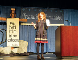 As she addresses participants at the Indiana Catholic Women&rsquo;s Conference in Indianapolis on March 10, Sonja Corbitt holds up a journal she used to record her thoughts after her daily reading of Scripture. (Photo by Natalie Hoefer)