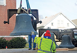 Workmen from The Verdin Company in Cincinnati lower onto a flatbed truck the largest bell&mdash;weighing 1,800 pounds&mdash;from the former Holy Trinity Church in Indianapolis on March 14. The three bells from the Slovenian-founded parish, which was merged in 2014, will be cleaned and eventually moved to St.&nbsp;Malachy Parish in Brownsburg. (Photos by Natalie Hoefer)