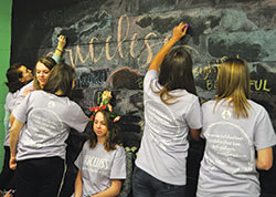 Teens write affirming words to describe Audrey Braughn, seated in the center, during the &ldquo;Priceless&rdquo; retreat at St. Malachy Parish in Brownsburg on April 6. Three teens of the parish designed the retreat with the help of their parish youth and campus ministries director. (Submitted photo)