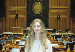 Sixteen-year-old Paige Moore poses in the House of Representatives chambers at the Indiana Statehouse in Indianapolis. The sophomore at Roncalli&nbsp;High School in Indianapolis successfully lobbied earlier this year for a new law that will benefit her and other students at private high schools in Indiana. (Photo by John Shaughnessy)