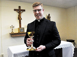 Standing on May 16 in the St. Alphonsus Liguori Chapel in the Archbishop Edward T. O&rsquo;Meara Catholic Center in Indianapolis, transitional Deacon Jeffrey Dufresne holds a chalice he received from the archdiocesan archives that he will use in the celebration of the Eucharist after he is ordained a priest at 10 a.m. on June 2 in SS. Peter and Paul Cathedral in Indianapolis. The liturgy is open to the public. (Photo by Sean Gallagher)