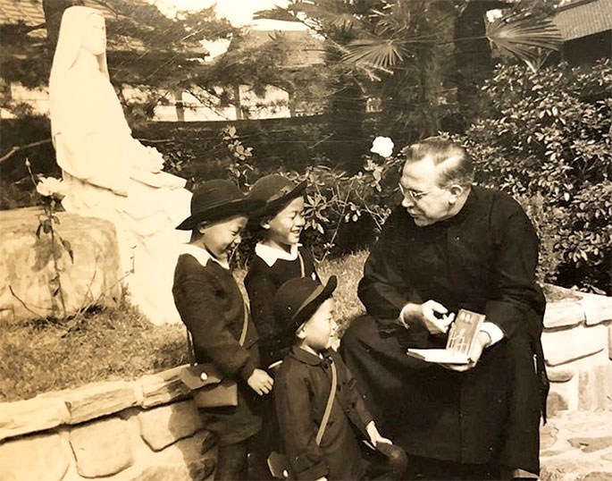 In this photo, Maryknoll Father Clarence Witte reads to children in Japan. Father Clarence, a native of Richmond, was ordained a Maryknoll missionary priest in 1935. He served in Japan from 1947-66, including a five-year term as the regional superior of priests of his order in Japan. Following his assignment in Japan, Father Clarence was sent to Bolivia to minister to Japanese immigrants. In 1976, he returned to Japan, where Father Clarence remained until his retirement and death in 2001. His autobiography, titled Quod est Demonstrandum: What It’s All About, was reviewed by Archbishop Daniel M. Buechlein in his weekly column in The Criterion on Sept. 28, 2001.