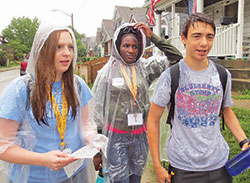 High schoolers Sarah Hagen, left, of St. Louis de Montfort Parish in Fishers, Ind., in the Diocese of Lafayette; Joan Njoroge of Holy&nbsp;Angels Parish in Indianapolis; and Aidan Galt of St. Barnabas Parish in Indianapolis navigate through an underserved neighborhood on the south&nbsp;side of Indianapolis searching for edible plants on June 21. The unique scavenger hunt aimed to help the students better understand poverty, and was part of the Missionary Disciples Institute hosted by Marian University in Indianapolis. (Photo by Katie Rutter)