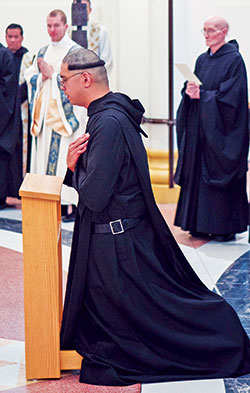 Benedictine Brother Lorenzo Penalosa kneels during a ritual after professing solemn vows on Aug. 15 as a monk of Saint Meinrad Archabbey in St. Meinrad. His hair has been cut in what is traditionally called a corona (Latin for &ldquo;crown&rdquo;). Among other things, it is a symbol of the humility at the heart of monastic life. (Photo courtesy of Saint Meinrad Archabbey)