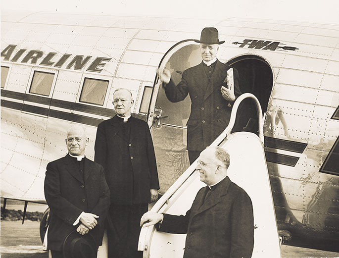 In this photo, Archbishop-designate Paul C. Schulte arrives in Indianapolis after his appointment as archbishop in 1946. Archbishop Schulte was appointed archbishop on July 20, 1946, and arrived in Indianapolis on Oct. 8 of that year. His installation at SS. Peter and Paul Cathedral in Indianapolis was held two days later. He had previously served as bishop of Leavenworth, Kan., beginning in 1937. From left to right in this picture are Msgr. Raymond Noll, archdiocesan vicar general; Msgr. Eugene Vallely, vicar general of the Diocese of Leavenworth; Archbishop Schulte, and Msgr. Henry Dugan, archdiocesan chancellor.