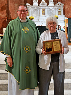 Patricia Vesper, a member of St. Luke the Evangelist Parish in Indianapolis, stands next to Father Joseph Feltz after receiving the 2018 Archbishop O&rsquo;Meara Respect Life Award at the archdiocesan Respect Life Mass at SS.&nbsp;Peter and Paul Cathedral on Oct. 7. Father Feltz presided at the archdiocesan Respect Life Mass. (Photo by Natalie Hoefer)
