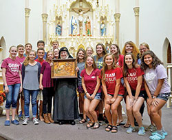 Benedictine Mother Dolores Hart, center, holds an image of the Holy Family given to her by members of St. Louis Parish in Batesville and poses with members of the parish&rsquo;s youth group on Sept. 30. Created by the local Weberding&rsquo;s Carving Shop, the image was a gift to the nun who visited the parish and shared her life story. (Submitted photo by Katie Rutter)