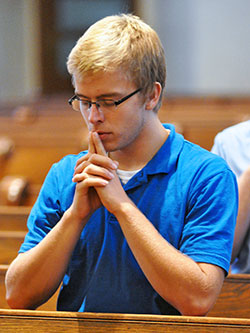Seminarian Charlie Wessel, a member of St. Simon the Apostle Parish in Indianapolis, kneels in prayer on Aug. 11, 2015, in St. Mary Church in New Albany during a pilgrimage taken during the annual archdiocesan seminarian convocation. Human&nbsp;formation programs at seminaries in the archdiocese help prepare men for the challenges of priestly life&nbsp;and ministry today. (File photo by Sean Gallagher)