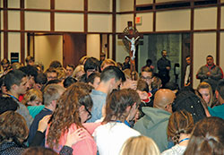 Teenagers from across the archdiocese come together in a moment of reverent silence before a crucifix during the &ldquo;ArchIndy Teen Experience&rdquo; at Butler&nbsp;University in Indianapolis on Nov. 4. (Photo by John Shaughnessy)