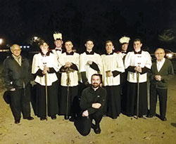 Father Dustin Boehm, pastor of St. Gabriel Parish in Connersville and St. Bridget of Ireland Parish in Liberty, poses with altar servers, members of the parish&rsquo;s Knights of Columbus and others prior to one of St. Gabriel&rsquo;s &ldquo;Novena of Sundays&rdquo; rosary walk evenings. (Submitted photo)
