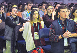 Colleen Tragonski, center, kneels with other young people in prayer on Jan. 6 during a Mass at the SEEK2019 conference that drew 17,000 mainly college students from across the country to the Indiana Convention Center in Indianapolis. &ldquo;The Holy Spirit is so present here, everywhere in the atmosphere,&rdquo; Tragonski said. &ldquo;That&rsquo;s the best way that I can put it.&rdquo; (Photo by Sean Gallagher) 