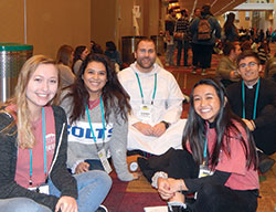 Dominican Father Patrick Hyde, associate pastor of St. Paul Catholic Center in Bloomington and head of the parish&rsquo;s campus ministry serving the students of Indiana University (IU), center, enjoys a break on Jan. 5 with IU students Jenna Fisher, Rachel Folstrom and Arianna Dacanay during SEEK2019 at the Indiana Convention Center in Indianapolis. Also pictured at right is Thomas Leah, a seminarian for the Archdiocese of Chicago. (Photo by Mike Krokos)