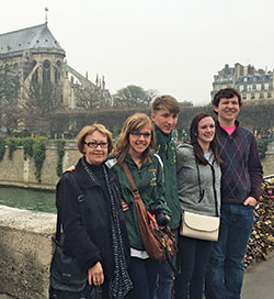 With Notre Dame Cathedral in the background, Aline Cambon poses with her students Caroline Wehner, second from left, Skip Maas, Hannah Storm and Myles Hesse during a trip she led to France. Cambone has been a French teacher at her alma mater, Father Michael Shawe Memorial Jr./Sr. High School in Madison, for&nbsp;40 years. (Submitted photo)