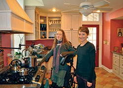 Suzanne Konnersman, left, and her sister Hilary Konnersman stand in their kitchen where Suzanne has learned to cook traditional, healthy food. Suzanne started the Kessing Haus Caf&eacute; in Oldenburg as a place for the community to gather in a unique coffee shop. (Photo by Jennifer Lindberg)