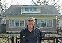 Robert &ldquo;Lanny&rdquo; Rossman smiles as he stands in front of the once-abandoned house in Indianapolis that he and his nephew Steve Adams spent 14 months transforming into a home for a single mother and her three children. (Photo by John Shaughnessy)