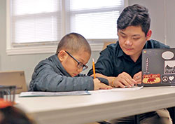 Yan Yan tutors a child as a volunteer for Hope&nbsp;for Tomorrow, an Indianapolis organization that helps Burmese children with their homework. (Submitted photo) 