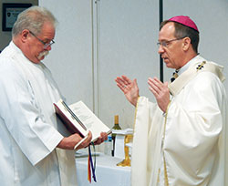 Altar server Tim&nbsp;Spreitzer of SS. Peter and Paul Cathedral Parish in Indianapolis holds the Missal for Archbishop Charles C. Thompson during a March 18 Mass celebrated during a Catholic Charities statewide conference at the Wellington Conference Center in Fishers, Ind., in the Lafayette Diocese. (Photo by Mike Krokos)