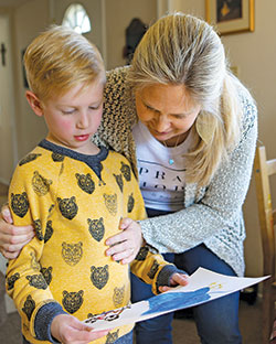Amy Laddbush examines the artwork crafted by one of her 11 children on March 6 in her Bowie, Md., home. Mother&rsquo;s Day is on May 12. (CNS photo/Chaz Muth)