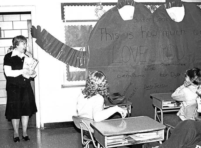 In this photo, eighth-grade students at St. Vincent de Paul School in Bedford celebrate Teacher Appreciation Day during Catholic Schools Week in January 1983. Their teacher was Franciscan Sister Joan Luerman. The writing on the giant paper heart reads, &ldquo;Sister Joan, This is how much we love you,&rdquo; and is signed by all of the members of the class.