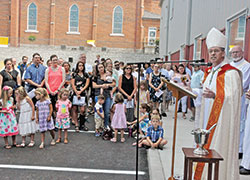 Members of St. Nicholas Parish in Ripley County and students at the faith community&rsquo;s school listen on Aug. 4 as Archbishop Charles C. Thompson preaches during a liturgy to bless the parish&rsquo;s new education center. (Photo by Sean Gallagher)