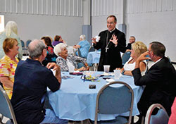 Archbishop Charles C. Thompson shares a lighthearted moment with parishioners of St. Mary Parish in Mitchell during the celebration of the parish&rsquo;s 150th anniversary on Aug. 11. (Submitted photo by Amy Marshek)