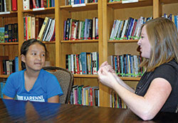 As a volunteer sign language interpreter for St. Pius X Parish in Indianapolis, Stephanie Campo translates God&rsquo;s message to 12-year-old parishioner Bae Meh, who is deaf. (Photo by John Shaughnessy)