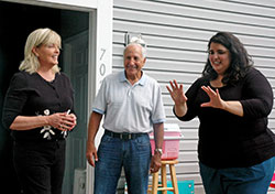 Alma Figueroa, right, shares her plans for the backyard of her family&rsquo;s home with Suzanne Thompson, executive director of Hearts & Hands of Indiana, and Paul Corsaro, one of the founding members of the organization dedicated to giving hope and houses to low-income families on the near-west side of Indianapolis. (Photo by John Shaughnessy)