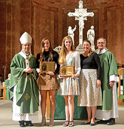 The recipients of this year&rsquo;s archdiocesan Our Lady of Guadalupe Pro-Life Youth Award smile with their plaques of recognition: Margaret &ldquo;Meggie&rdquo; McPherson of St. Pius X Parish in Indianapolis, left, and Sally Jones of Immaculate Heart of Mary Parish in Indianapolis. They received the plaques from Archbishop Charles C. Thompson, archdiocesan Office of Human Life and Dignity coordinator Brie Anne Varick, and Deacon Michael Braun, archdiocesan Secretariat for Pastoral Ministries director, during the Respect Life Mass at SS. Peter and Paul Cathedral in Indianapolis on Oct. 6. (Photo by Natalie Hoefer)
