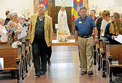 Archdiocesan director of catechesis Ken Ogorek, left, and archdiocesan coordinator of catechetical resources James Wood process with a statue of Our Lady of Fatima during the archdiocese&rsquo;s Morning with Mary event in Church of the Immaculate Conception at Saint Mary-of-the-Woods, in St. Mary-of-the-Woods, on Oct. 5. (Photo by Natalie Hoefer)